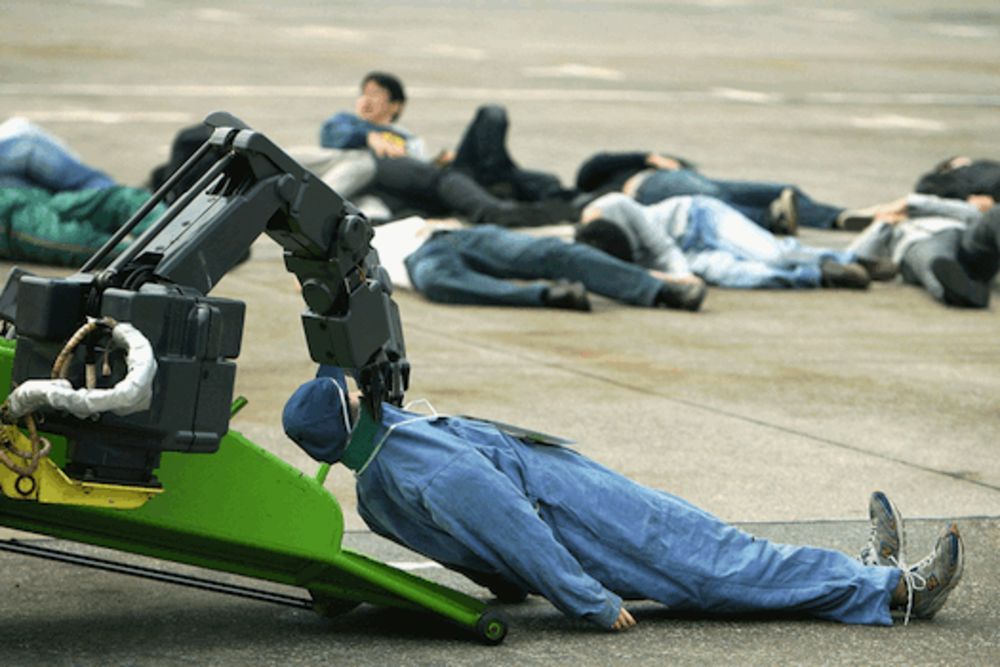 Robot de secours ramassant des blessés à Tokyo et servant d'allégorie à la machine broyeuse d'humains.