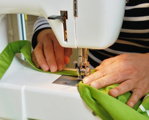 Mais de femmes travaillant sur une machine à coudre