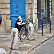 Homme assis devant une porte dans la rue