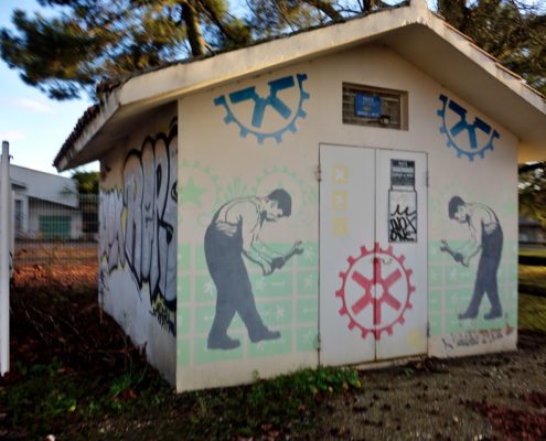 Cabane de maintenance avec fresque décorative représentant des rouages et des ouvriers